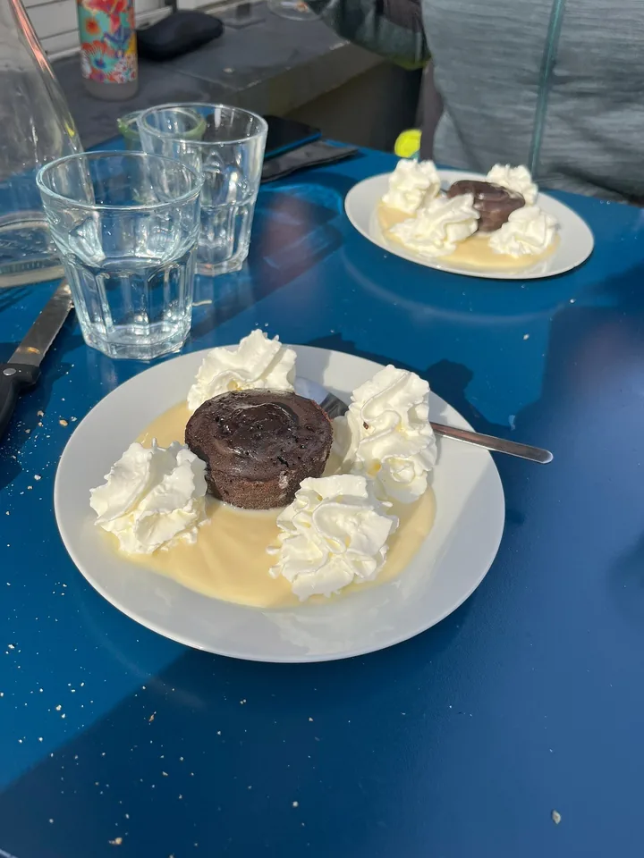 Moelleux au chocolat avec chantilly et crème anglaise, sur une table bleue