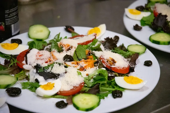 Salade composée avec œufs durs, tomates, concombre, olives noires et parmesan